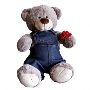 Peluche de oso con ropa azul y flores rojas.