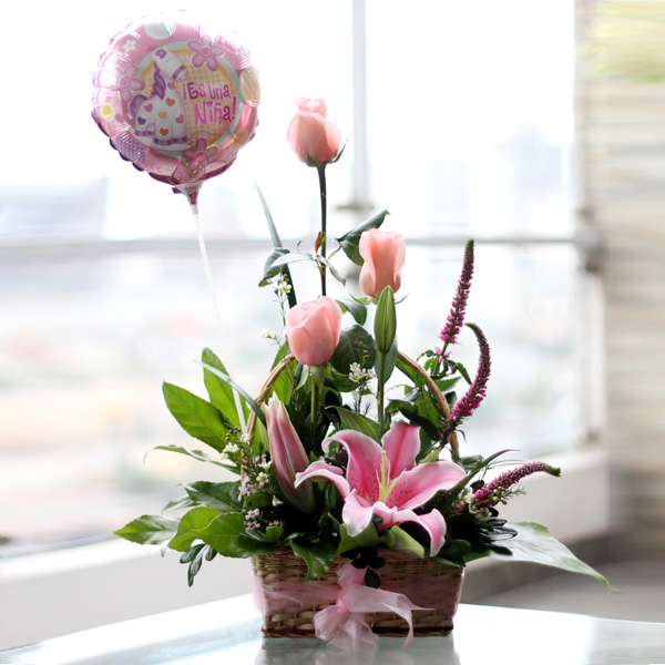 Canasta con lindas flores rosadas y globo pequeño.