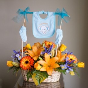 Canasta con flores y accesorios de recién nacido.