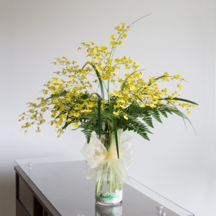 Florero de vidrio con flores amarillas