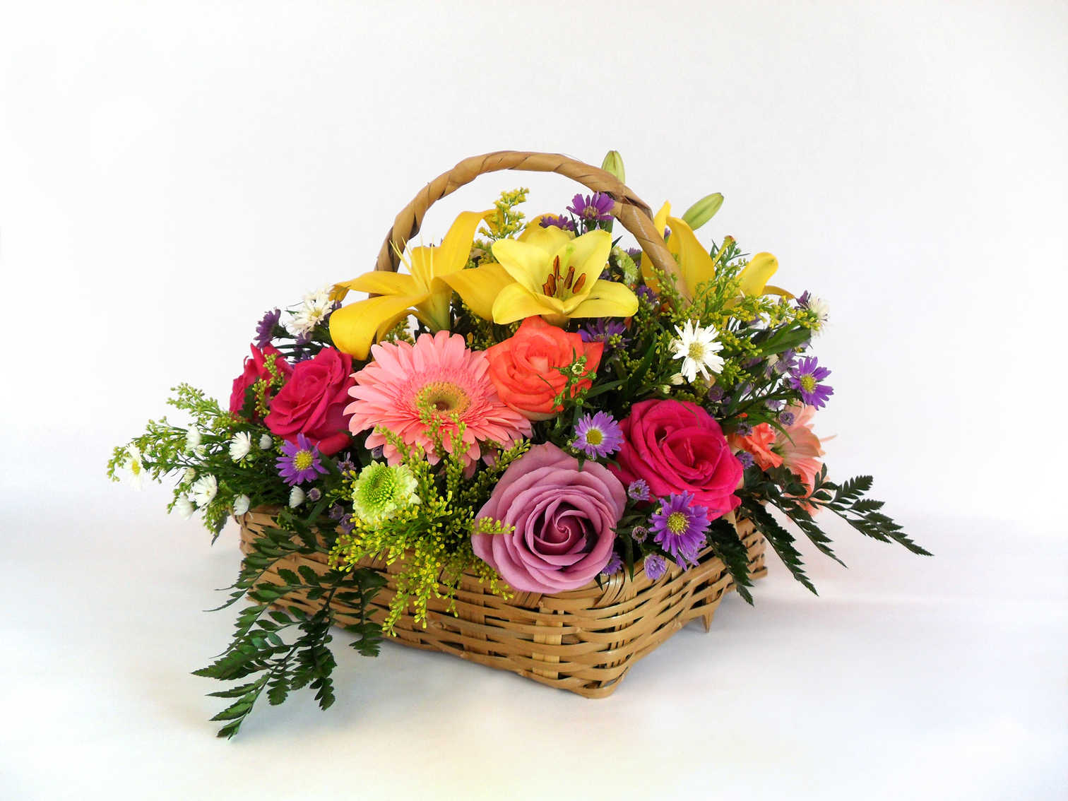 Canasta areglo floral rosas, gerberas, margaritas y follaje.