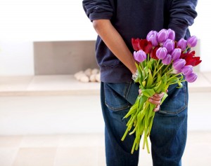 Chico con tulipanes de color morado y rojo