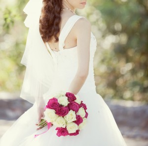 pink and white wedding bouquet of roses in the hands of the brid