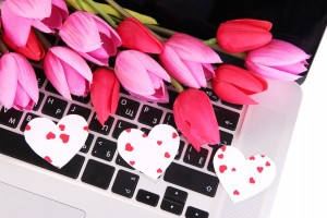 Bright hearts and flowers on computer keyboard close up