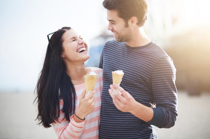 Pareja de enamorados paseando y comiendo helados.