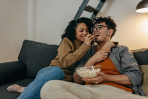 Pareja viendo películas y comiendo palomitas.