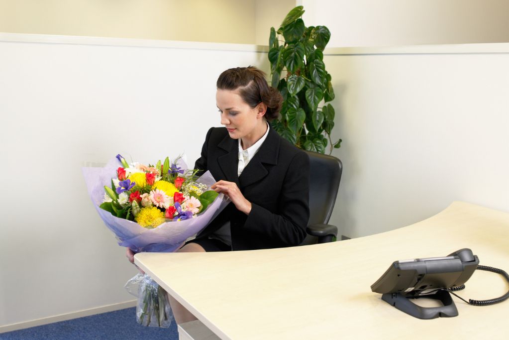 Secretaria recibiendo flores por su día.