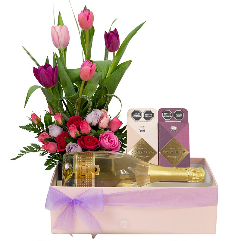 Caja de regalo con arreglo de mini rosas y tulipanes, espumante y dos barras de chocolate.