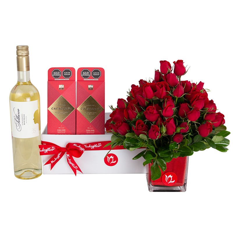 Caja de regalo con vino, arreglo de mini rosas rojas y dos barras de chocolate.