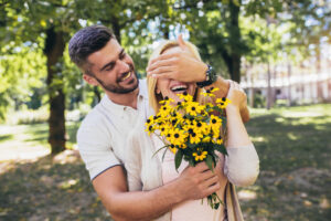 Novio sorprendiendo a su pareja con flores.